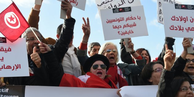 Tunisians shout slogans during a demonstration outside parliament against allowing Tunisians who joined the ranks of jihadist groups to return to the country, in the capital Tunis on December 24, 2016. The writing in Arabic reads: ''Tunisian leaders why are you so scared?'' / AFP / FETHI BELAID (Photo credit should read FETHI BELAID/AFP/Getty Images)
