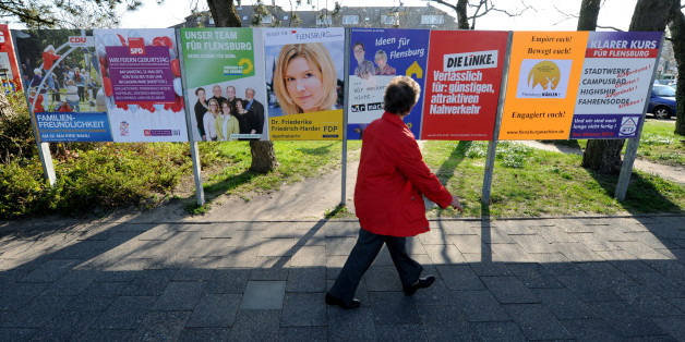 Eine Frau geht an Wahlplakaten vorbei