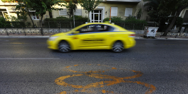 A taxi drives by fading Olympic rings which mark the Olympic Traffic Lane on an avenue leading to the Athens 2004 Olympic Complex in Athens July 26, 2014. Ten years after Greece hosted the world's greatest sporting extravaganza, many of its once-gleaming Olympic venues have been abandoned while others are used occasionally for non-sporting events such as conferences and weddings. For many Greeks who swelled with pride at the time, the Olympics are now a source of anger as the country struggles through a six-year depression, record unemployment, homelessness and poverty. Just days before the anniversary of the Aug. 13-29 Games in 2004, many question how Greece, among the smallest countries to ever host the Games, has benefited from the multi-billion dollar event. Picture taken July 26, 2014. REUTERS/Yannis Behrakis (GREECE - Tags: BUSINESS POLITICS SPORT TRANSPORT)
ATTENTION EDITORS: PICTURE 25 OF 33 FOR WIDER IMAGE PACKAGE 'TEN YEARS ON - ATHENS' FADING OLYMPIC STADIUMS'
TO FIND ALL IMAGES SEARCH 'BEHRAKIS KARAHALIS'