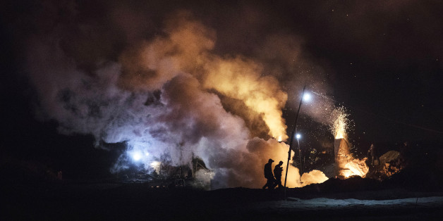 INNER MONGOLIA, CHINA - NOVEMBER 03:Chinese labourers walk as smoke and steam rises at a cooling pit and furnace at an unauthorized steel factory on November 3, 2016 in Inner Mongolia, China. To meet China's targets to slash emissions of carbon dioxide, authorities are pushing to shut down privately owned steel, coal, and other high-polluting factories scattered across rural areas. In many cases, factory owners say they pay informal 'fines' to local inspectors and then re-open. The enforcement comes as the future of U.S. support for the 2015 Paris Agreement is in question, leaving China poised as an unlikely leader in the international effort against climate change. U.S. president-elect Donald Trump has sent mixed signals about whether he will withdraw the U.S. from commitments to curb greenhouse gases that, according to scientists, are causing the earth's temperature to rise. Trump once declared that the concept of global warming was 'created' by China in order to hurt U.S. manufacturing. China's leadership has stated that any change in U.S. climate policy will not affect its commitment to implement the climate action plan. While the world's biggest polluter, China is also a global leader in establishing renewable energy sources such as wind and solar power. (Photo by Kevin Frayer/Getty Images)