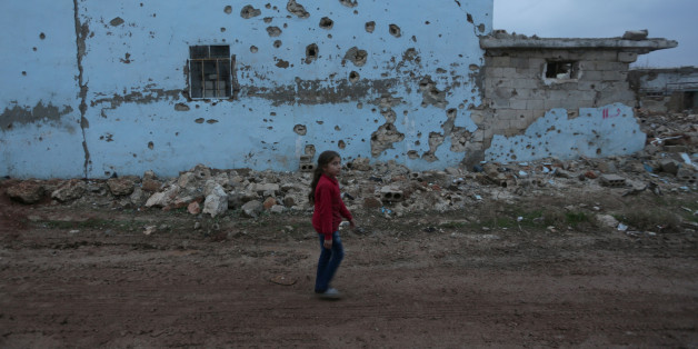 A girl walks near a damaged house in al-Rai town, northern Aleppo province, Syria December 27, 2016. REUTERS/Khalil Ashawi