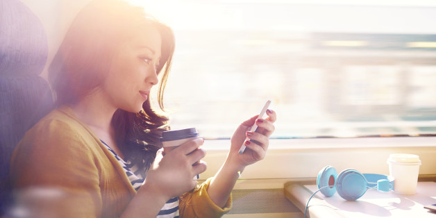 Woman on a commuter train looking at her phone.