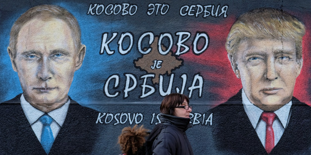 A woman with a child walks past a mural of U.S. president-elect Donald Trump and Russian President Vladimir Putin in Belgrade, Serbia, December 4, 2016. The text on the mural reads in Russian, Serbia and English "Kosovo is Serbia". REUTERS/Marko Djurica