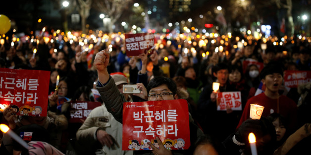 People march toward the constitutional court during a protest demanding South Korean President Park Geun-hye's resignation in Seoul, South Korea December 17, 2016. The sign reads "Arrest Park Geun-hye". REUTERS/Kim Hong-Ji