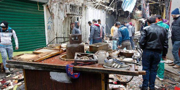 Iraqis look at the aftermath following a double bomb attack in a busy market area in Baghdad's central al-Sinek neighbourhood on December 31, 2016. Baghdad has been on high alert since the start on October 17 of an offensive, Iraq's largest military operation in years, to retake the northern jihadist stronghold of Mosul / AFP / SABAH ARAR (Photo credit should read SABAH ARAR/AFP/Getty Images)