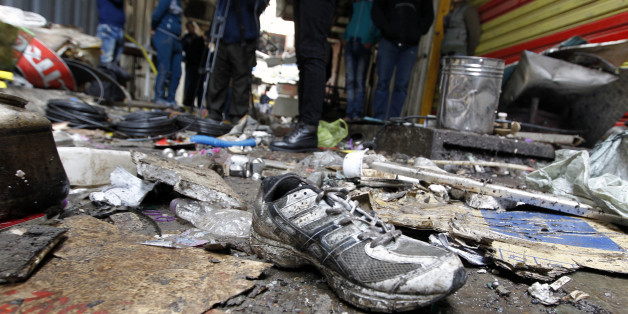 Iraqis look at the aftermath following a double blast in a busy market area in Baghdad's central al-Sinek neighbourhood on December 31, 2016. Baghdad has been on high alert since the start on October 17 of an offensive, Iraq's largest military operation in years, to retake the northern jihadist stronghold of Mosul / AFP / SABAH ARAR (Photo credit should read SABAH ARAR/AFP/Getty Images)