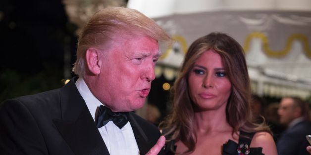 US President-elect Donald Trump answers questions from reporters accompanied by wife Melania for a New Year's Eve party December 31, 2016 at Mar-a-Lago in Palm Beach, Florida. / AFP / DON EMMERT (Photo credit should read DON EMMERT/AFP/Getty Images)