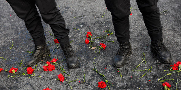 Flowers are placed next to Turkish police officers as they stand guard near the Reina nightclub, which was attacked by a gunman, in Istanbul, Turkey, January 1, 2017. REUTERS/Umit Bektas