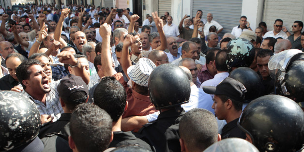 Protesters confront police officers during a demonstration in front of the headquarters of the General Union of Tunisian Workers in Tunis October 10, 2012. Tunis was paralyzed by a public transport strike that caused violence in the centre and some suburbs of the Tunisian capital. REUTERS/Zoubeir Souissi (TUNISIA - Tags: POLITICS CIVIL UNREST)