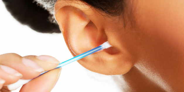 Young, beautiful, happy woman cleans her ear