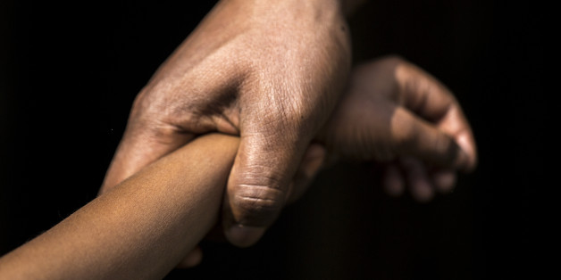 Adult holding a child's wrist