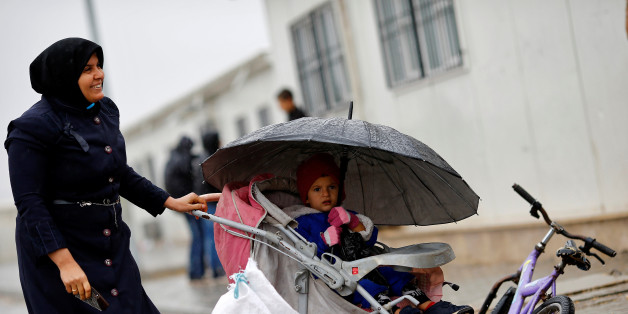 A Syrian refugee woman strolls with her child in Elbeyli refugee camp near the Turkish-Syrian border in Kilis province, Turkey, December 1, 2016. REUTERS/Umit Bektas