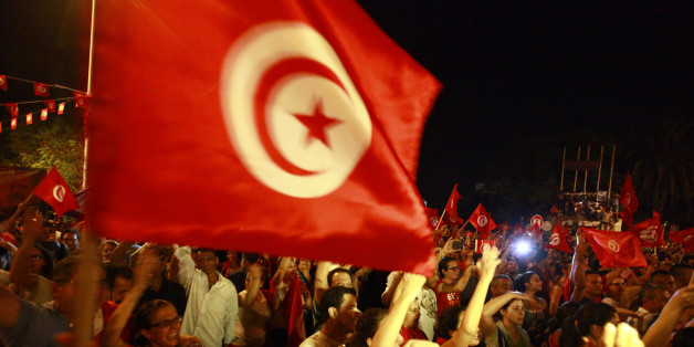 Anti-government protesters wave national flags during a demonstration in Tunis August 6, 2013. Tens of thousands of Tunisians crowded the streets of downtown Tunis on Tuesday to demand the transitional government's ouster, in the largest opposition protest since the country's political crisis began two weeks ago. The secular opposition, angered by two assassinations in its ranks and emboldened by the army-backed toppling of Egypt's Islamist president, is trying to topple Tunisia's Islamist-led government and dissolve the Constituent Assembly. REUTERS/Anis Mili (TUNISIA - Tags: POLITICS CIVIL UNREST)