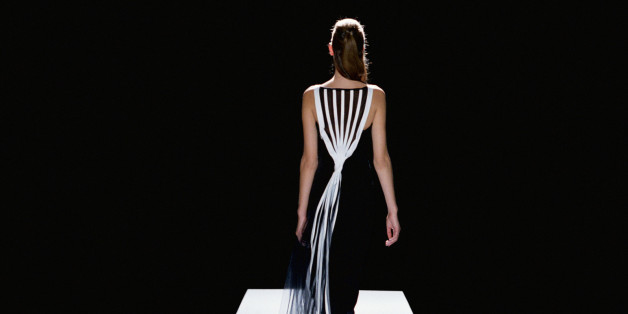 Fashion model in black and white gown walking catwalk, rear view