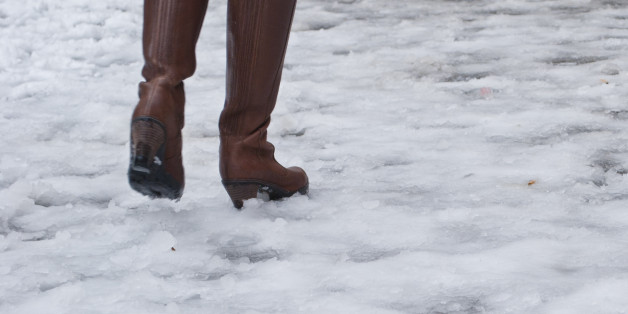 Woman with brown leather boots walks on icy street in Rome