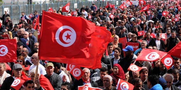Tunisians wave their national flag and chant slogans during a march against extremism outside Tunis' Bardo Museum on March 29, 2015. Thousands of Tunisians set off for a march 'against terrorism' through the capital following the massacre of foreign tourists at the country's national museum. AFP PHOTO / FETHI BELAID (Photo credit should read FETHI BELAID/AFP/Getty Images)