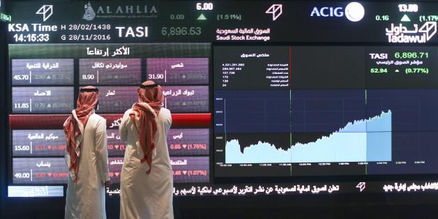 Visitors stand and watch stock movements displayed on large video screens inside the Saudi Stock Exchange, also known as the Tadawul All Share Index in Riyadh, Saudi Arabia, on Monday, Nov.28, 2016. The Tadawul All Share Index advanced 26 percent since Saudi Arabias record-breaking bond sale last month, the most in the world during that period. Photographer: Simon Dawson/Bloomberg via Getty Images