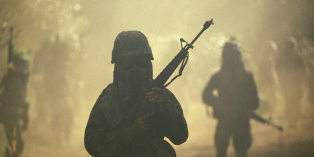 SOLDIERS IN GAS MASKS PATROLLING FOREST