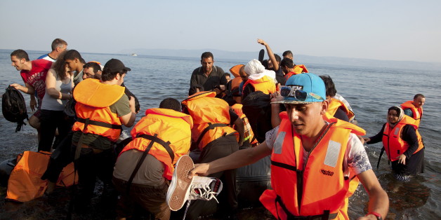 A Frontex helicopter patrols over Syrian refugees arriving on an overcrowded dinghy at a beach at the Greek island of Lesbos August 10, 2015. Thousands of refugees and migrants are stranded on Greek islands -- in some cases for over two weeks -- waiting for temporary documents before continuing their travel to northern Europe. The United Nations refugee agency (UNHCR) called on Greece to take control of the "total chaos" on Mediterranean islands, where thousands of migrants have landed. About 124,000 have arrived this year by sea, many via Turkey, according to Vincent Cochetel, UNHCR director for Europe. REUTERS/Antonis Pasvantis