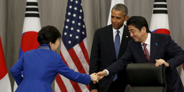 U.S. President Barack Obama stands behind as South Korean President Park Geun-Hye (L) and Japanese Prime Minister Shinzo Abe shake hands at the end of their trilateral meeting at the Nuclear Security Summit in Washington March 31, 2016. REUTERS/Kevin Lamarque