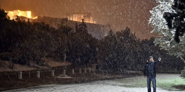 A man takes a selfie with the Acropolis in the background during heavy snowfall in central Athens on the night of January 9, 2017.
A cold snap gripping Europe has killed more than 30 people in recent days, left thousands of travellers stranded in snow-covered Turkey and brought fresh misery for migrants and the homeless. / AFP / LOUISA GOULIAMAKI (Photo credit should read LOUISA GOULIAMAKI/AFP/Getty Images)