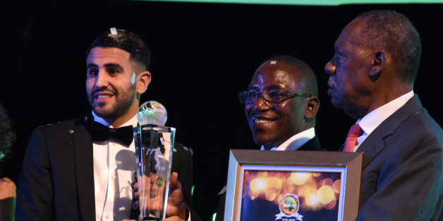 Algerian and Leicester forward Riyad Mahrez (L) receives trophy from Nigeria's sports minister Solomon Dalung (C) and CAF President Issa Hayatou after being crowned African Footballer of the Year in Abuja, on January 5, 2017.Algerian and Leicester striker Riyad Mahrez has been crowned the CAF African best Footballer for 2016 and beating former best player and Gabonese forward Pierre-Emerick Aubameyang and Sehegalese striker Sadio Mane, for the continent's most prestigious individual award. / A