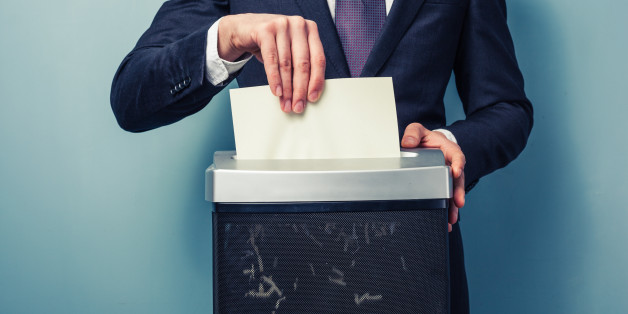 A Businessman is shredding important documents