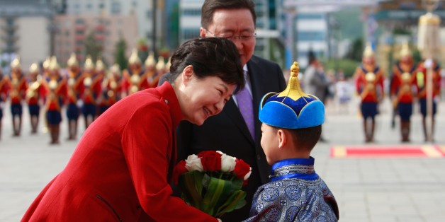 South Korea's President Park Geun-hye (L) is greeted by a Mongolian boy as Mongolia's President Tsakhiagiin Elbegdorj looks on during a welcoming ceremony for Park in Ulan Bator on July 17, 2016.Park is on a state visit to Mongolia after attending the 11th Asia-Europe Meeting (ASEM) summit. / AFP / BYAMBASUREN BYAMBA-OCHIR (Photo credit should read BYAMBASUREN BYAMBA-OCHIR/AFP/Getty Images)