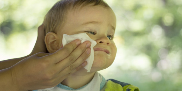 Mother cleans the baby with wet wipes