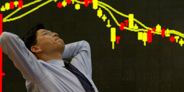 FILE PHOTO: A South Korean employee of a securities firm reacts in front of a graph showing stock price in Seoul March 11, 2003. REUTERS/Kim Kyung-Hoon/File photo