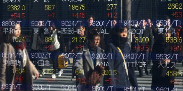 Pedestrians are reflected in an electric quotation board flashing stock prices on the Tokyo Stock Exchange in Tokyo on January 4, 2017.Tokyo shares surged in the morning on January 4 on the first trading day of 2017, following gains on Wall Street driven by optimism over the US economy. / AFP / KAZUHIRO NOGI (Photo credit should read KAZUHIRO NOGI/AFP/Getty Images)