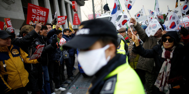 Supporters (R) of South Korean President Park Geun-hye march past a group of people (L) demanding President Park Geun-hye's resignation, during a protest opposing her impeachment in Seoul, South Korea December 17, 2016. REUTERS/Kim Hong-Ji