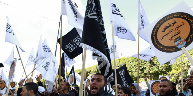 Supporters of the Islamist party "Hizb Ut-Tahrir" movement wave flags during a rally at central Habib Bourguiba Avenue, as they protest against the new Constitution, in Tunis January 24, 2014. REUTERS/Anis Mili (TUNISIA - Tags: CIVIL UNREST POLITICS)