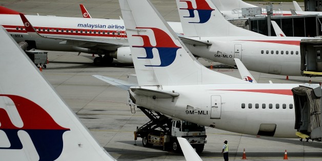 Malaysia Airlines ground staff walk past Malaysia Airlines aircraft parked on the tarmac at the Kuala Lumpur International Airport in Sepang on June 20, 2016. Malaysia is hosting a two-day meeting with Australia and China to discuss next steps in the fruitless search for missing Malaysia Airlines flight MH370. / AFP / MANAN VATSYAYANA (Photo credit should read MANAN VATSYAYANA/AFP/Getty Images)