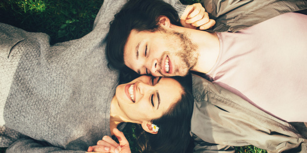 Happy young couple lying on the grass