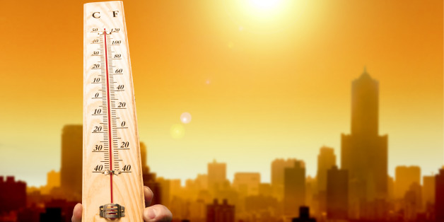 heat wave in the city and hand showing thermometer for high temperature