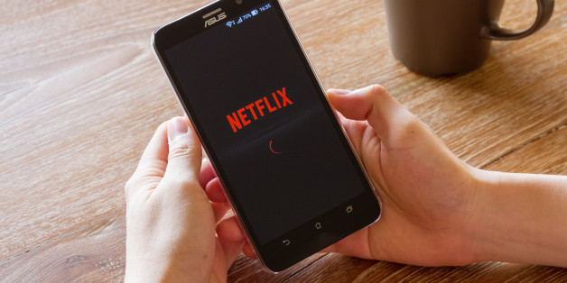 Chiang Mai, Thailand - April 26, 2016: man hand holding screen shot of Netflix application showing on Asus Zenfone 2 mobile phone. Netflix is a global provider of streaming movies and TV series.
