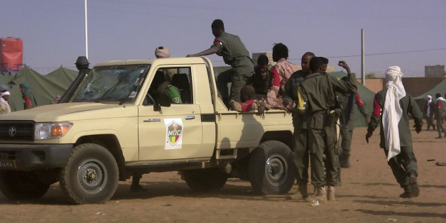 EDITORS NOTE: Graphic content / Soldiers gather at a pickup truck following a suicide bomb attack that ripped through a camp grouping former rebels and pro-government militia in Gao, in the troubled northern Mali left 50 people dead on January 18, 2017 in Gao.
Malian president's office ordered three days of national mourning following the attack, the worst in the country in recent years. / AFP / STRINGER (Photo credit should read STRINGER/AFP/Getty Images)