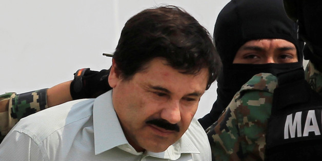 Joaquin "El Chapo" Guzman (L) is escorted by soldiers during a presentation at the Navy's airstrip in Mexico City February 22, 2014. REUTERS/Henry Romero/File Photo