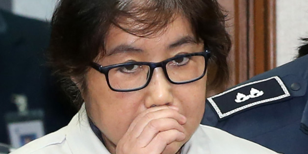 Choi Soon-Sil (C), who has been dubbed Korea's 'female Rasputin' for the influence she wielded over the now-impeached president Park Geun-Hye, arrives at a courtroom for her trial at the Seoul Central District Court in Seoul on December 19, 2016.The woman at the centre of a corruption scandal that triggered the biggest political crisis for a generation in South Korea appeared in court on December 19 for a preliminary hearing in her trial on fraud charges. / AFP / KOREA POOL / KOREA POOL / South