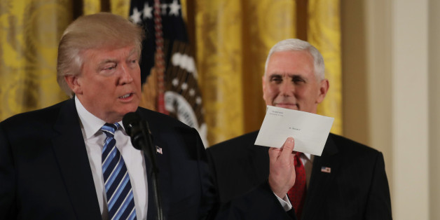 U.S. President Donald Trump shows a letter from former President Barack Obama at a swearing-in ceremony for senior staff at the White House in Washington, DC January 22, 2017. REUTERS/Carlos Barria