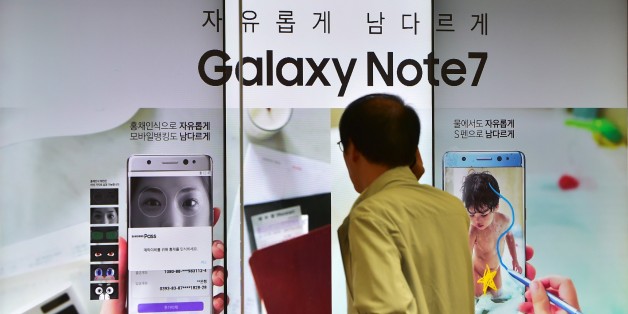A man speaks over his phone in front of a signboard of the Samsung Galaxy Note7 at a Samsung showroom in Seoul on September 2, 2016.
Samsung will suspend sales of its latest high-end smartphone Galaxy Note 7 after reports of exploding batteries, its mobile chief said on September 2. / AFP / JUNG YEON-JE (Photo credit should read JUNG YEON-JE/AFP/Getty Images)