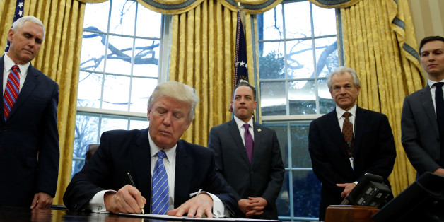 U.S. President Donald Trump, watched by (L-R) Vice President Mike Pence, White House Chief of Staff Reince Priebus, head of the White House Trade Council Peter Navarro and senior advisor Jared Kushner, signs an executive order that places a hiring freeze on non-military federal workers in the Oval Office of the White House in Washington January 23, 2017. REUTERS/Kevin Lamarque