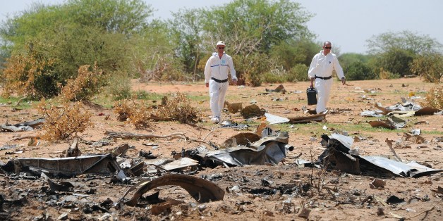 Forensics gather evidence at the crash site of the Air Algerie AH5017 in Mali's Gossi region, on July 29, 2014. France said on July 28 the pilots of the Air Algerie passenger plane that crashed in Mali, killing all 118 people on board, had asked to turn back in a new development to a complex probe into the tragedy. Reports that the crew asked to amend their route because of bad weather conditions emerged almost as soon as the tragedy came to light on July 24, but the revelation that they subsequ