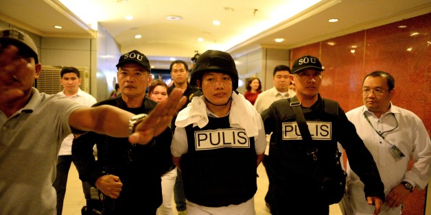 Police officer Ricky Sta. Isabel (C), one of the suspects in the kidnapping and murder of South Korean businessman Jee Ick Joo, is escorted by fellow policemen as they leave the National Bureau of Investigation (NBI) building in Manila on January 20, 2017. A South Korean businessman kidnapped by Philippine policemen under the guise of a raid on illegal drugs was murdered at the national police headquarters in Manila, authorities said Thursday. / AFP / NOEL CELIS (Photo credit should read