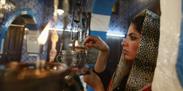 A Jewish worshipper lights an oil lamp during a pilgrimage to the El Ghriba synagogue in Djerba April 28, 2013. Africa's oldest synagogue is playing host to that rarity in the Arab world - a religious gathering of hundreds of Jews drawn from Europe and Israel. Guarded by armed Tunisian police, Jewish revellers chant and dance in a three-day pilgrimage to the El Ghriba synagogue at an island resort 500 km south of Tunis. REUTERS/Anis Mili (TUNISIA - Tags: RELIGION)