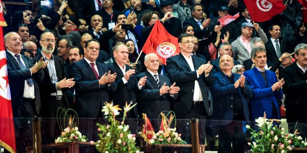 Secretary general of the General Union of Tunisian Workers (UGTT), Houcine Abbassi (5th from L), and his cabinet wave to crowds during the opening of the union's 23rd congress in the capital Tunis on January 22, 2017. / AFP / FETHI BELAID (Photo credit should read FETHI BELAID/AFP/Getty Images)