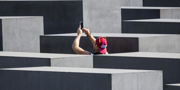 BERLIN, GERMANY - SEPTEMBER 04: Tourists taking a photo of the concrete slabs, stelae of the Memorial to the Murdered Jews of Europe on September 04, 2014, in Berlin, Germany. The monument is designed by architect Peter Eisenman and engineer Buro Happold. Photo by Thomas Trutschel/Photothek via Getty Images)***Local Caption***