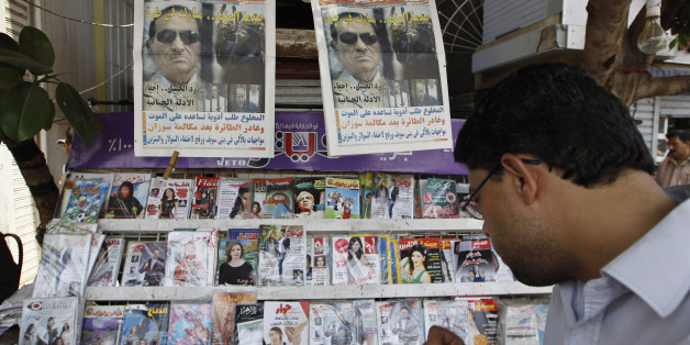 A man reads the headlines of local newspapers in Cairo June 3, 2012, a day after former leader Hosni Mubarak was handed a life prison sentence. Egyptian pro-democracy campaigners called for a new uprising on Sunday, enraged that a court had spared Mubarak his life over the killing of protesters during the street revolt that ended his three-decade rule. REUTERS/Ammar Awad (EGYPT - Tags: POLITICS CIVIL UNREST)