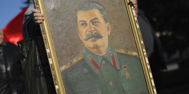 A woman marches amid red Soviet flags holding a portrait of Soviet dictator Josef Stalin during a rally marking Stalin's birthday anniversary of at his hometown in Gori, west of capital Tbilisi, December 21, 2014. REUTERS/David Mdzinarishvili (GEORGIA - Tags: ANNIVERSARY POLITICS SOCIETY)
